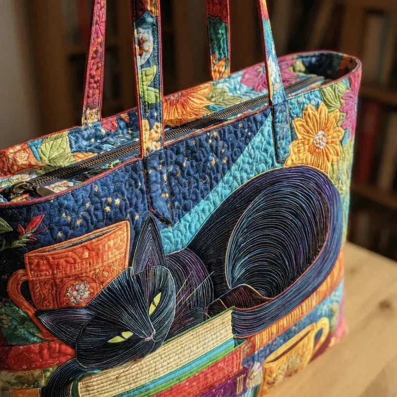 Quilted patchwork tote bag with black cat applique, colorful books, and long handles
