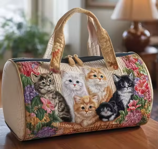 Soft travel bag with printed cat faces, quilted look, top handle and side panels