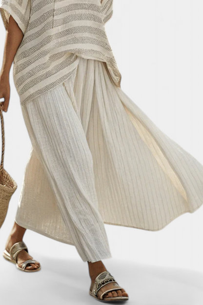 Cream striped poncho-style blouse and pleated skirt, matching elegant set