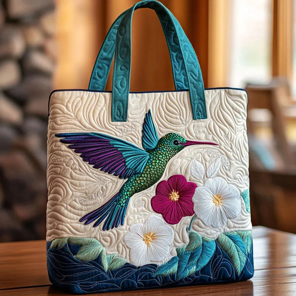 Handcrafted quilted bag with hummingbird and flower embroidery, teal handles, blue trim