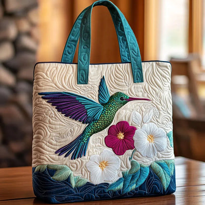 Handcrafted quilted bag with hummingbird and flower embroidery, teal handles, blue trim