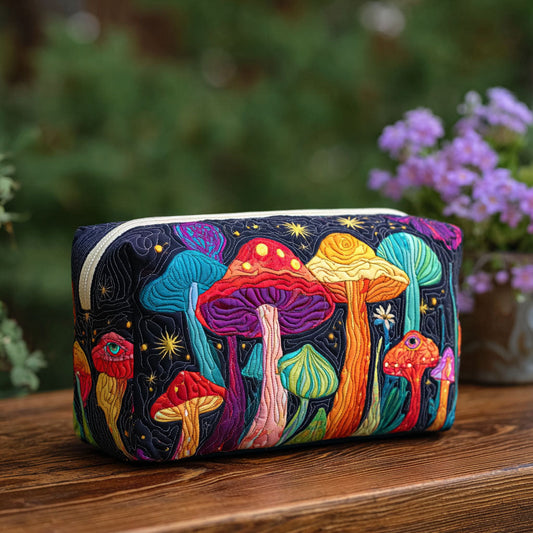 Quilted make-up bag with colorful embroidered mushrooms, zipper top, rounded rectangular shape.