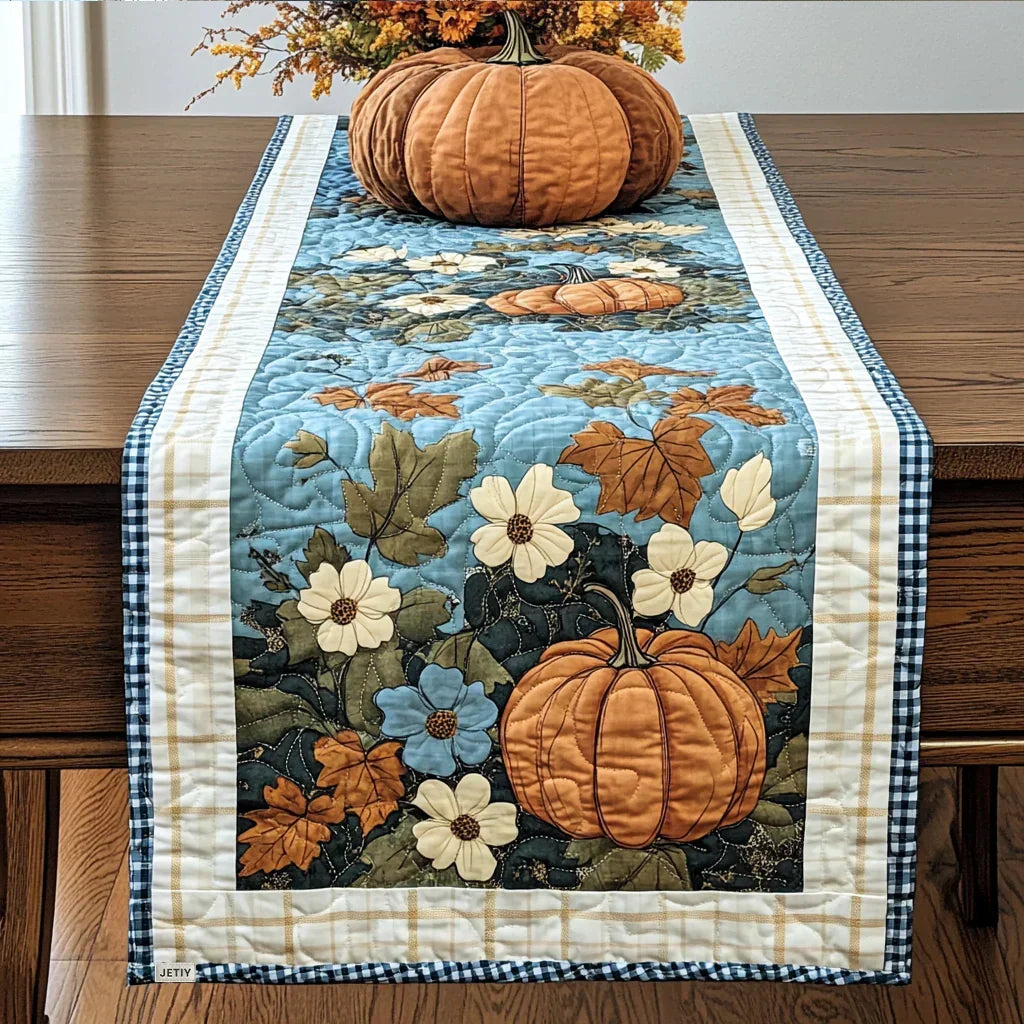 Quilted table runner in blue with autumn flowers, pumpkins, and stitched border
