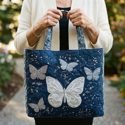 Handcrafted tote bag held open, dark navy quilted fabric with silver butterfly embroidery
